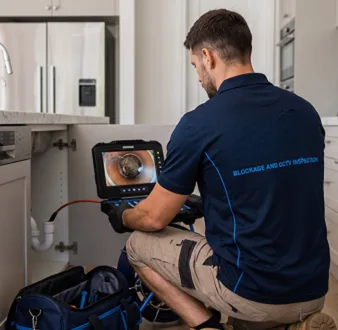 Plumber clearing a blocked toilet in a Bellevue Hill bathroom